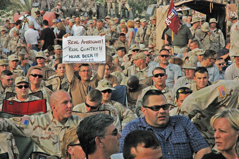 A Soldier holds up a sign while waiting for Toby Keith