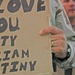 A Soldier holds a sign for his loved ones during the concert