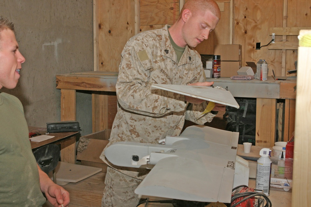 Sgt Patrick W. Broughal sands a damaged Dragon Eye