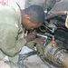 Spc. Dredatis Cook tightens the bolts on a generator