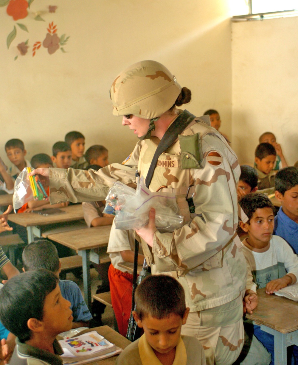 Capt. Adrian J. Crimmins passes out school supplies