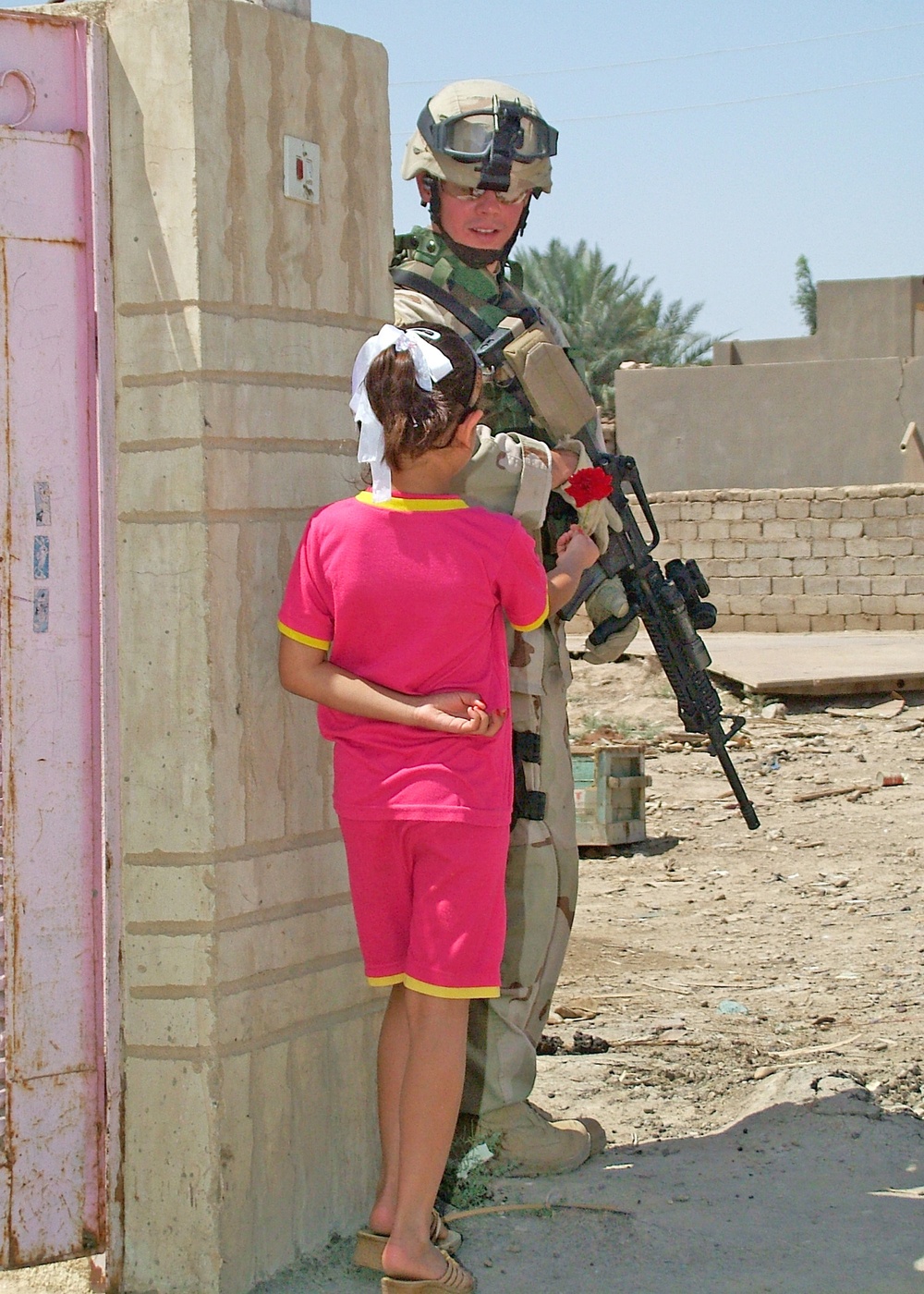 aA young Iraqi girl presents Sgt. Ford a single red rose