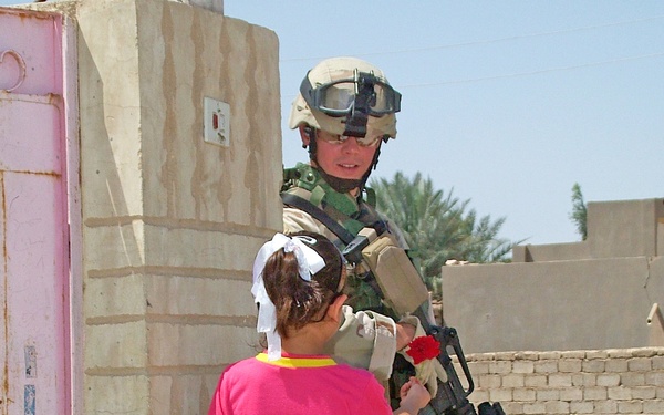 aA young Iraqi girl presents Sgt. Ford a single red rose