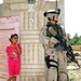 Sgt. Ford watches a neighborhood street with an Iraqi girl