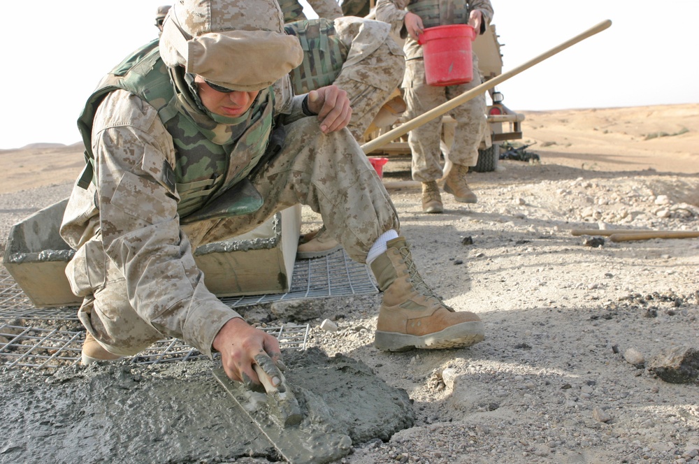 Lcpl. Patterson smoothes concrete poured into a crater