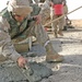 Lcpl. Patterson smoothes concrete poured into a crater