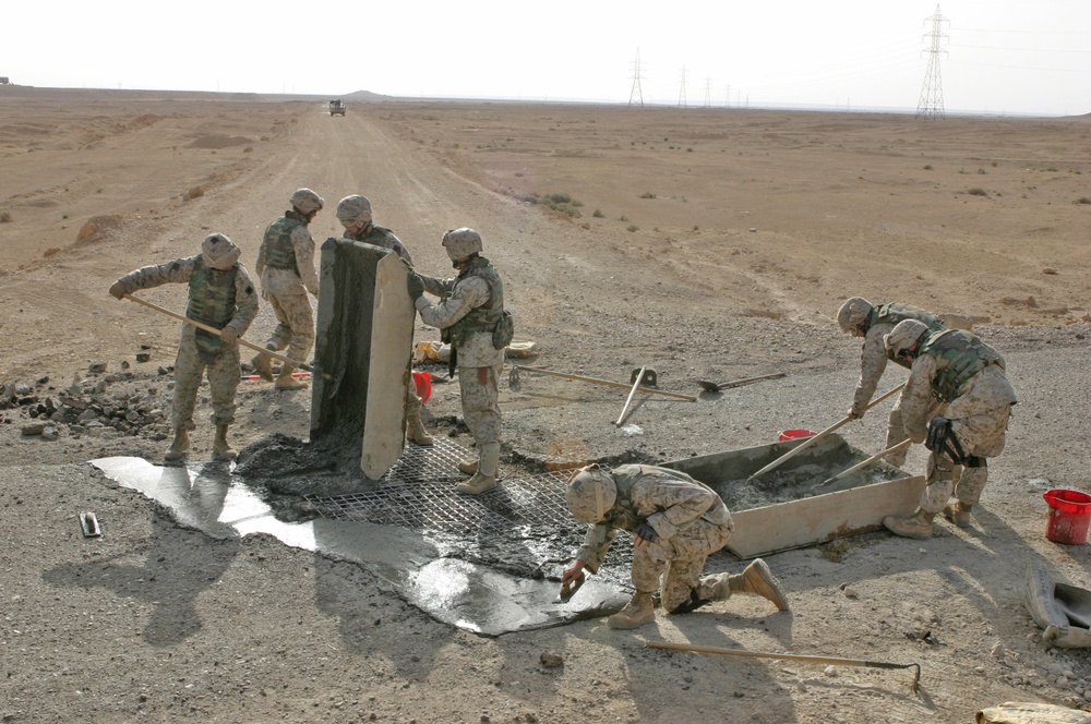 Marines repair a crater in a Western Iraqi road recently