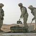 Marines mix concrete to pour into a crater in Western Iraq