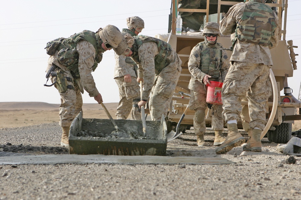 Marines mix concrete to pour into a crater in Western Iraq