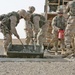 Marines mix concrete to pour into a crater in Western Iraq