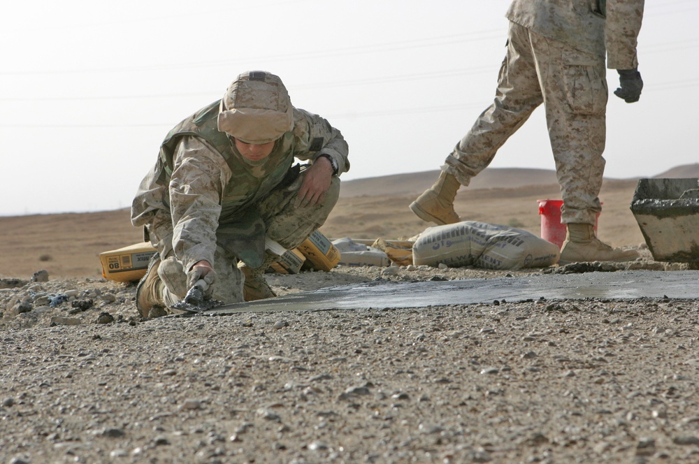 Lcpl. Patterson smoothes concrete poured into a crater