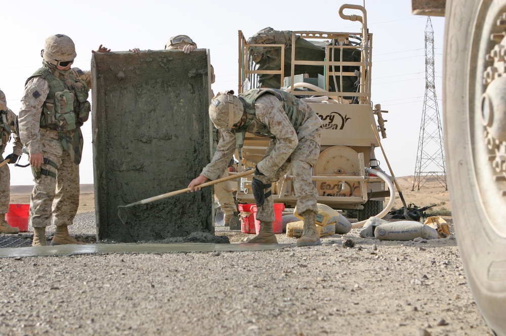 Marines pour concrete into a crater in Western Iraq