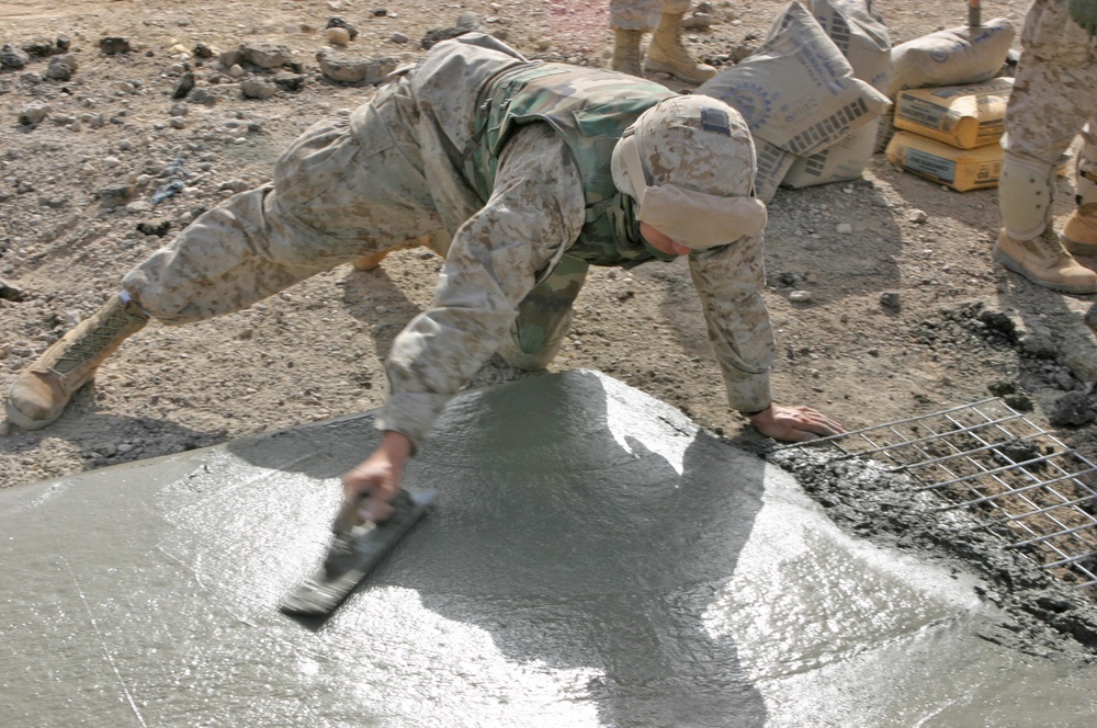 Lcpl. Patterson smoothes concrete poured into a crater