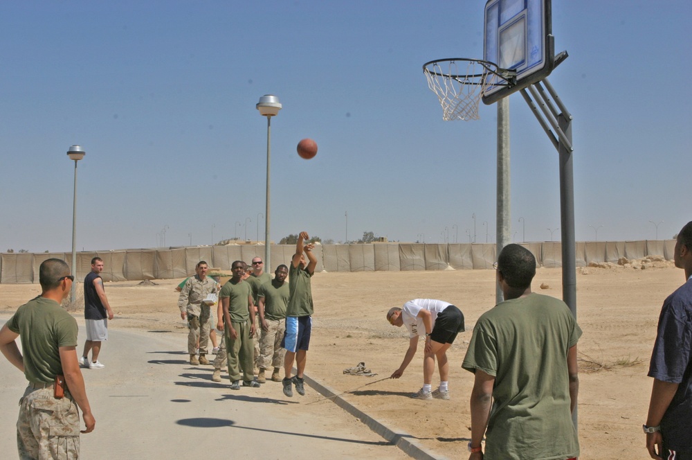 Sailors shoot hoops during a cookout and sporting day