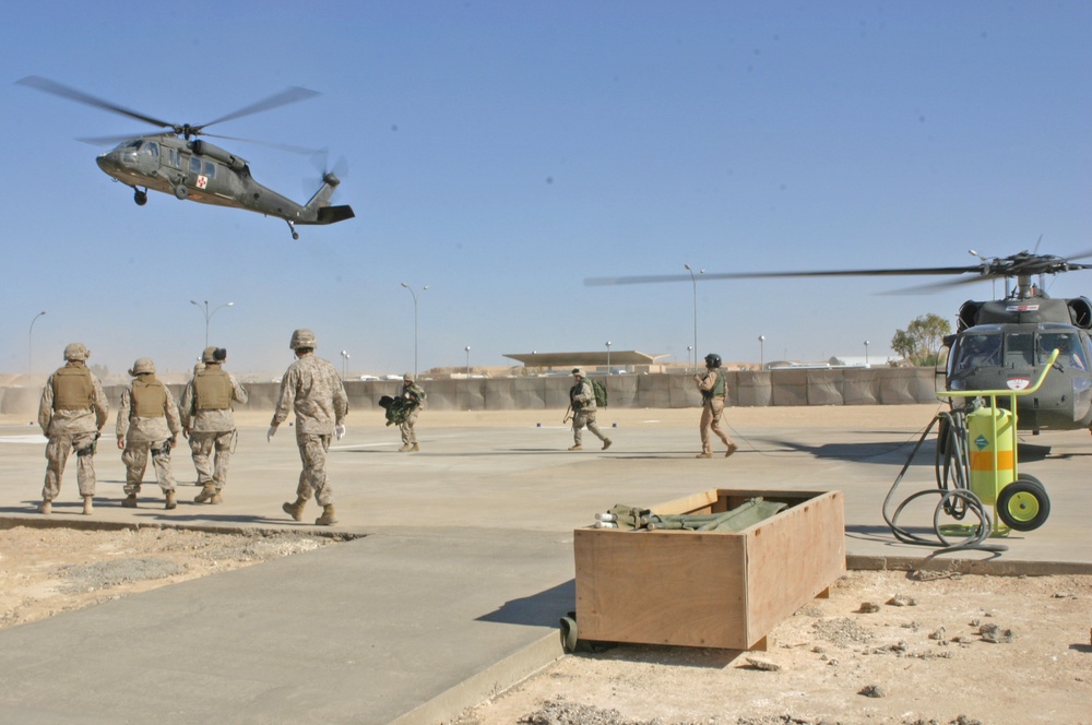 Sailors rush to an Army UH-60Q (Blackhawk) helicopter