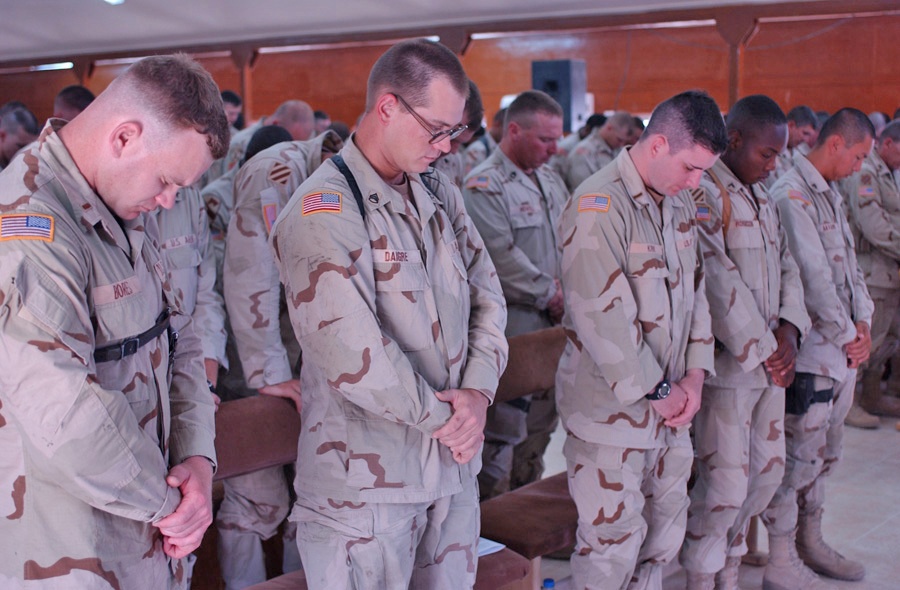Soldiers say a silent prayer for their fallen friends
