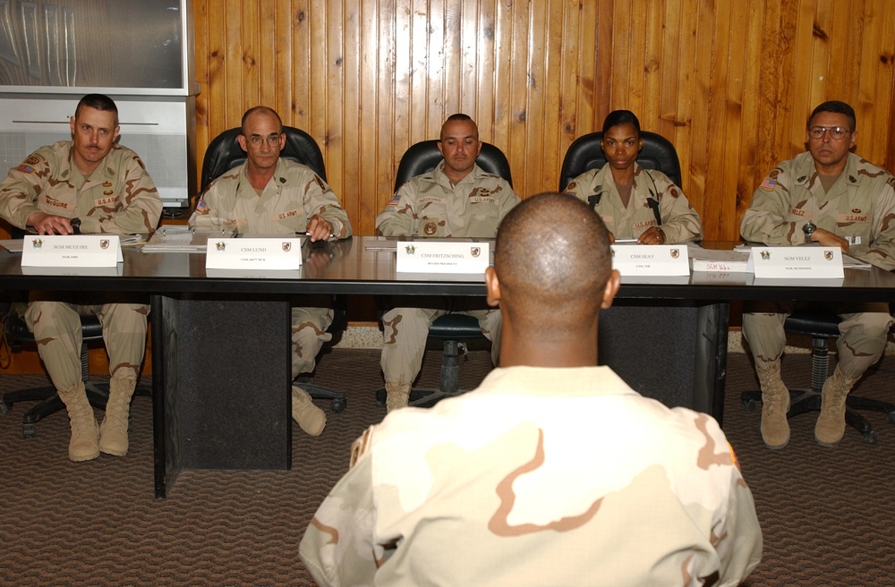 A Soldier sits in front of a board of five sergeants major