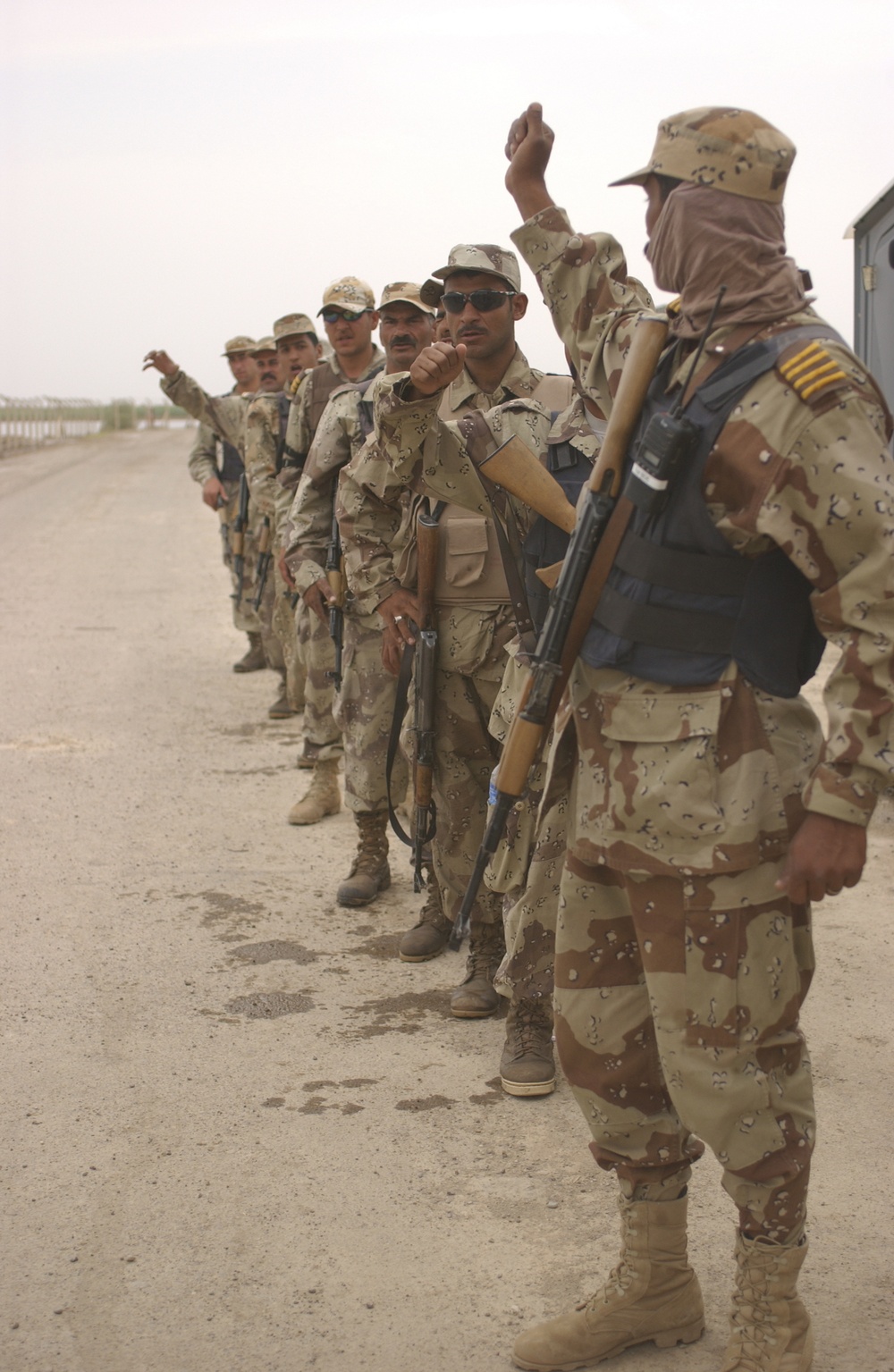 Iraqi army solidiers stand use hand and arm signals