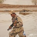 An Iraqi army soldier move through the water