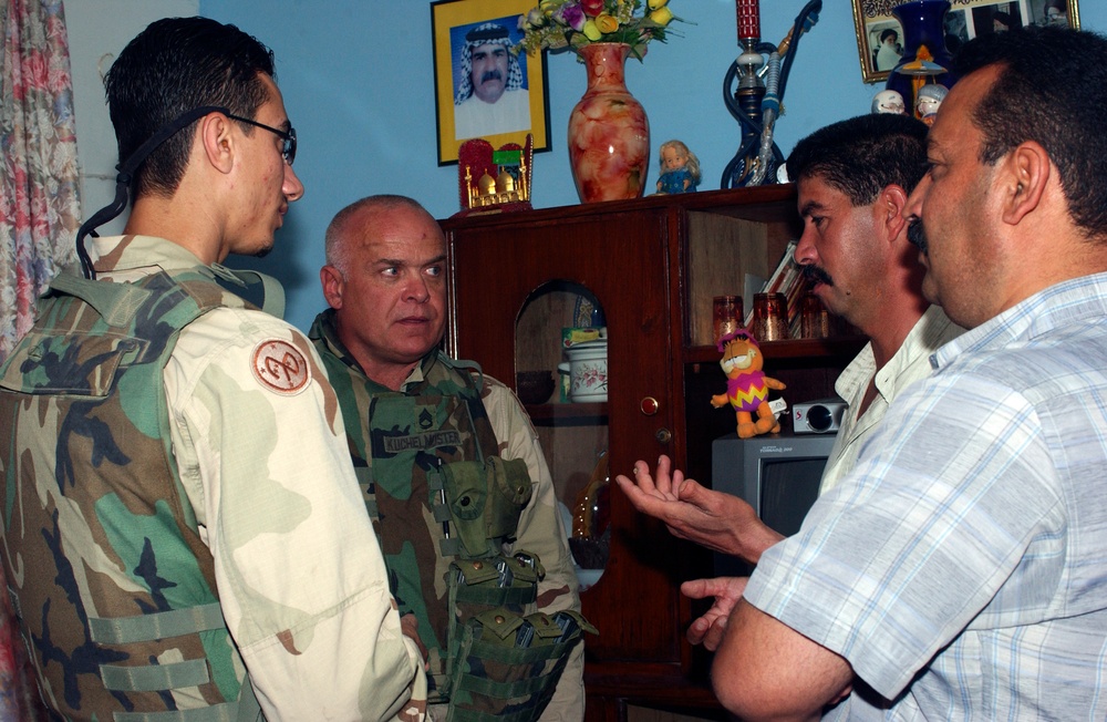 SFC Todd Kuchelmeister talks with local Iraqi leaders