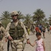 Cpl. Michael Geiger hold a little Iraqi girls hand