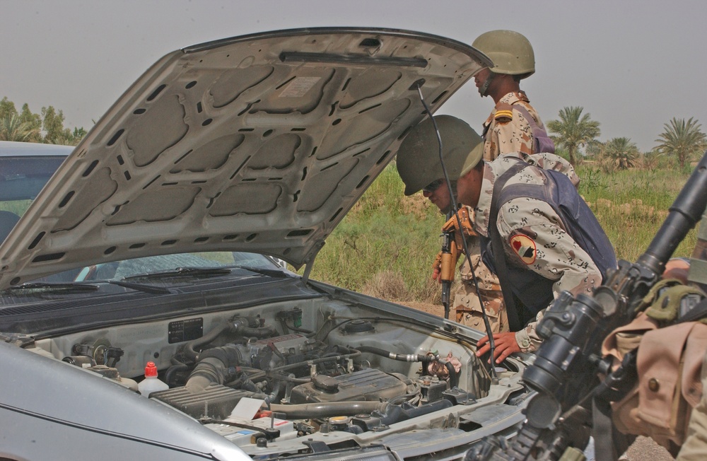 A Task Force 1-128 Soldier observes an Iraqi army soldier