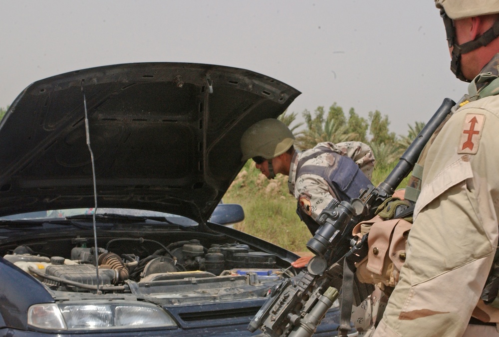 A Task Force 1-128 Soldier observes an Iraqi army soldier