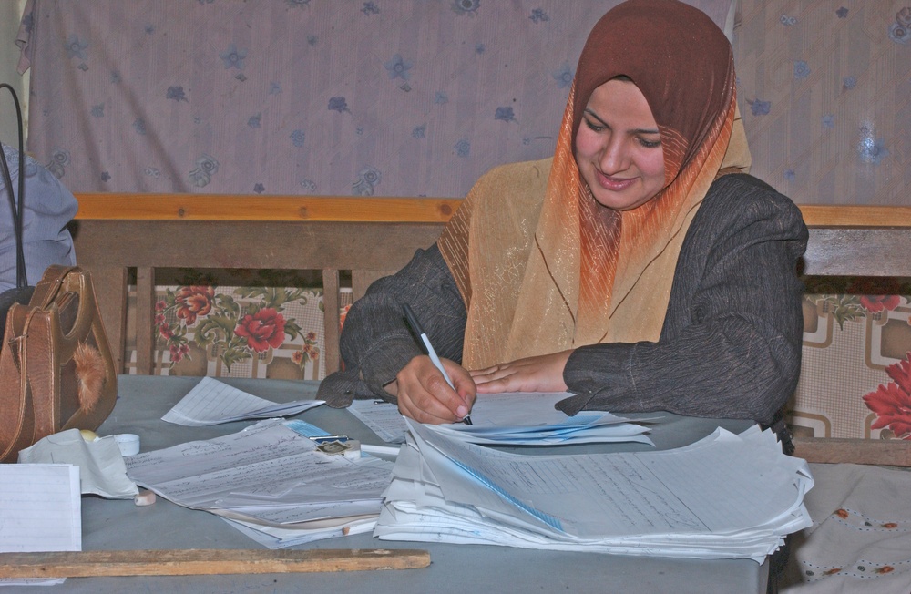 A Iraqi teacher grades papers at an all girls school