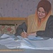 A Iraqi teacher grades papers at an all girls school