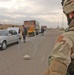 A Soldier watches as a Iraqi police search a vehicle