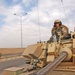 A soldier stands guard in an M3A3 Bradley Fighting Vehicle