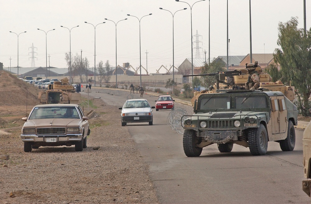 Soldiers watch traffic pass as they proceede through