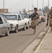 Soldiers visually inspect vehicles waiting to enter