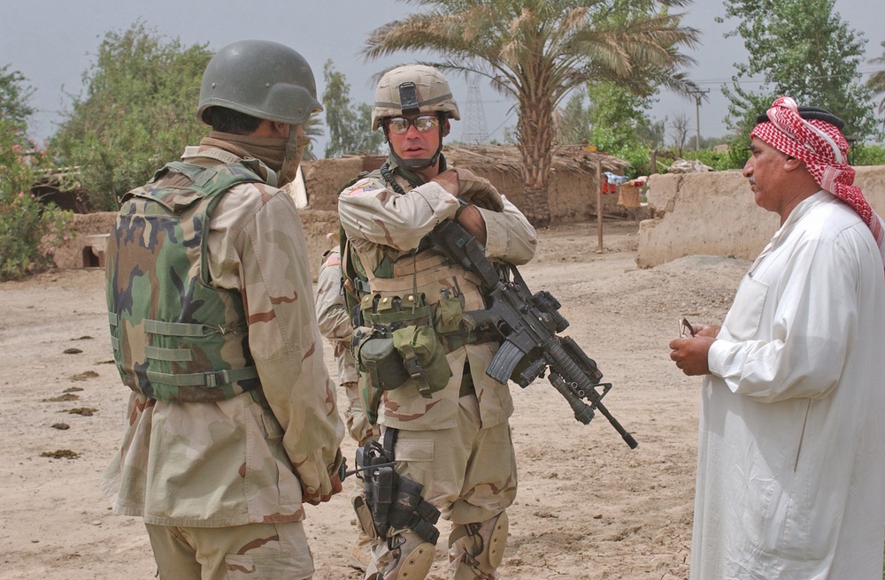 Sgt. 1st Class Brian Faltinson talks with an Iraqi man