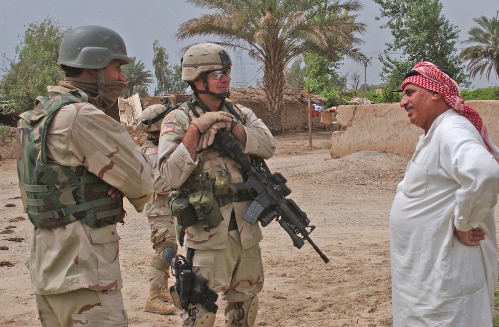 Sgt. 1st Class Brian Faltinson talks with an Iraqi man