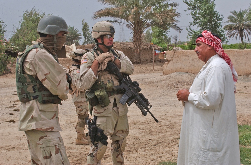 Sgt. 1st Class Brian Faltinson talks with an Iraqi man