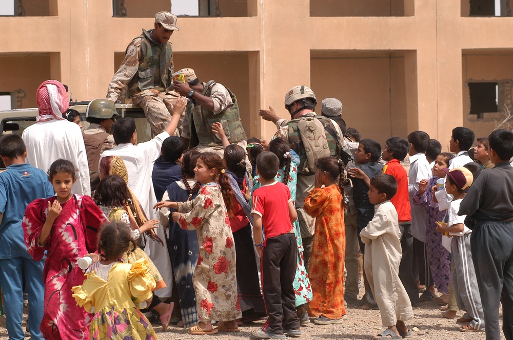 Iraqi children crowd around an Iraqi Army vehicle