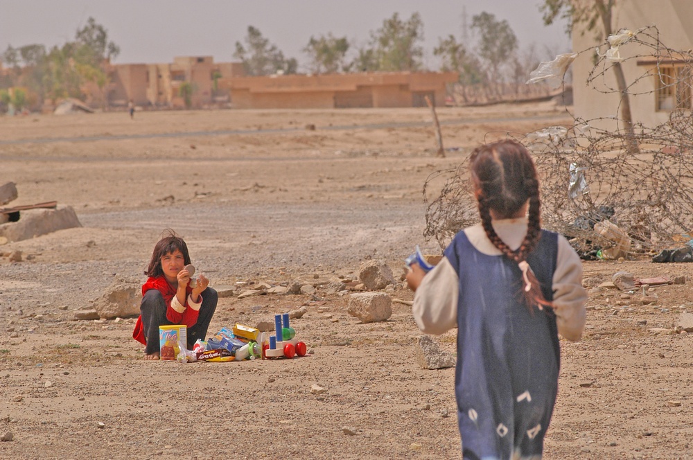 An Iraqi child watches over her share of toys