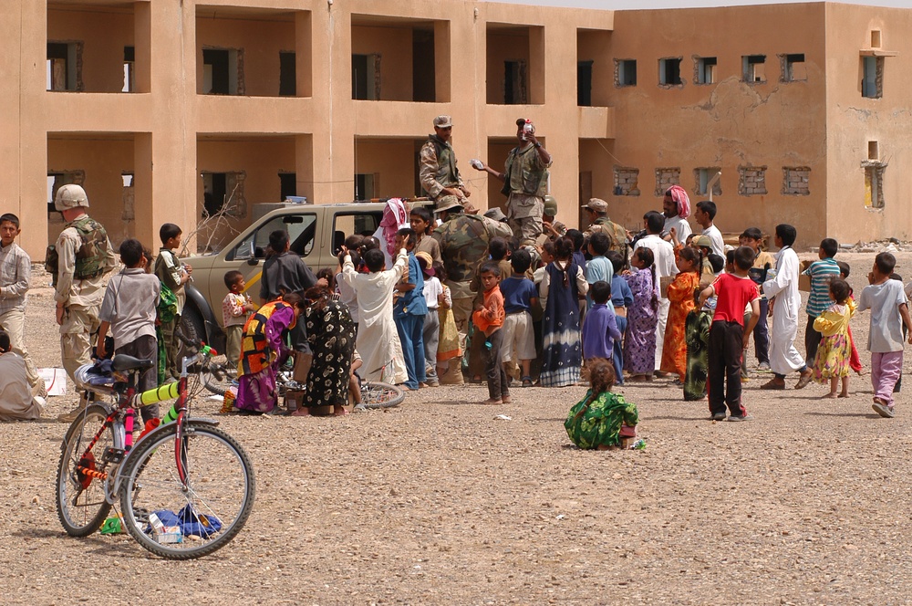 Iraqi children crowd around an Iraqi Army vehicle