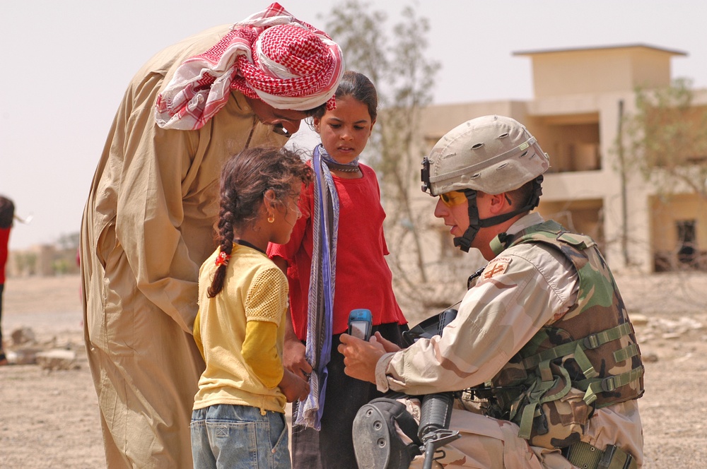 Sgt. Rothermel shows an Iraqi child a Motorola radio