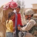 Sgt. Rothermel shows an Iraqi child a Motorola radio