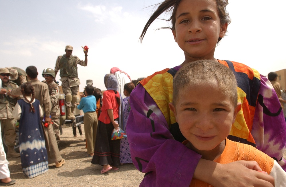 An Iraqi girl embraces her brother during a visit