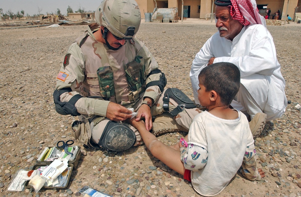 SSgt. Imperato dresses the wound of an Iraqi child