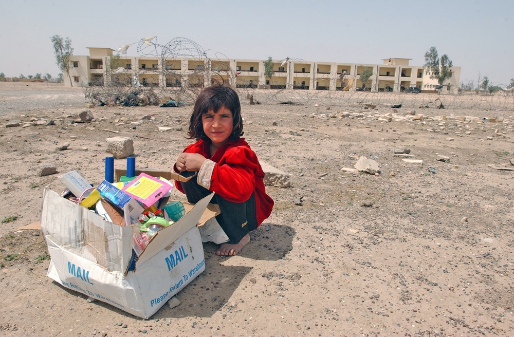 An Iraqi child watches over her share of toys/candy