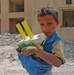 A small Iraqi boy holds toys and candy