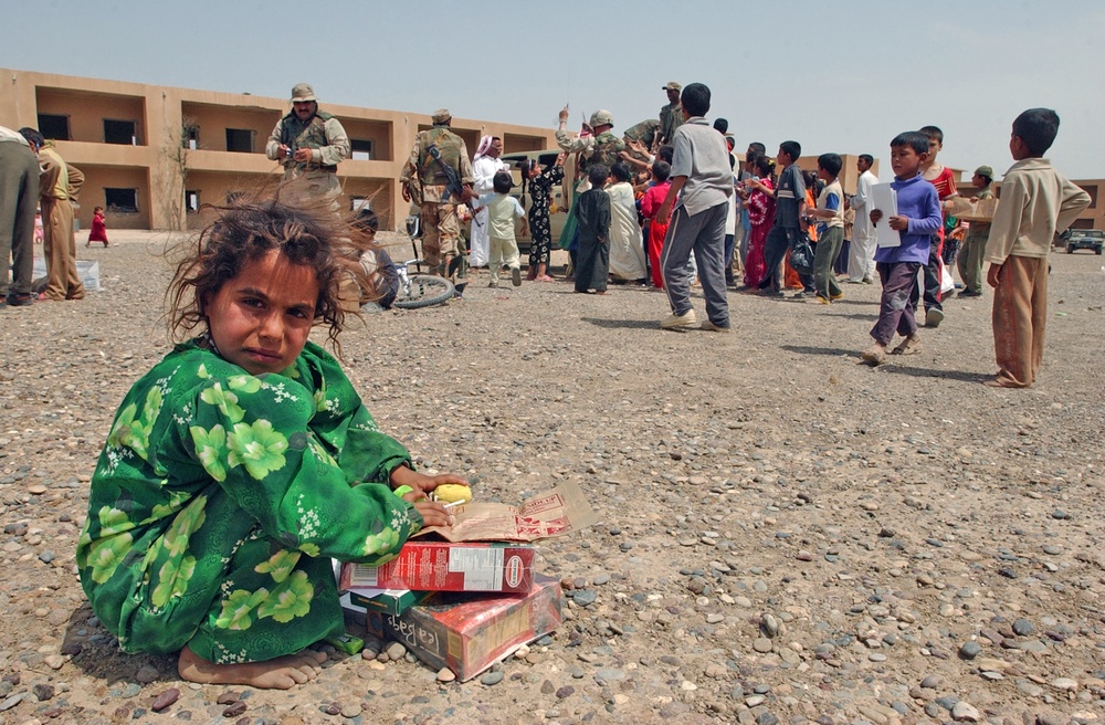 An Iraqi child guards her takings of food and toys