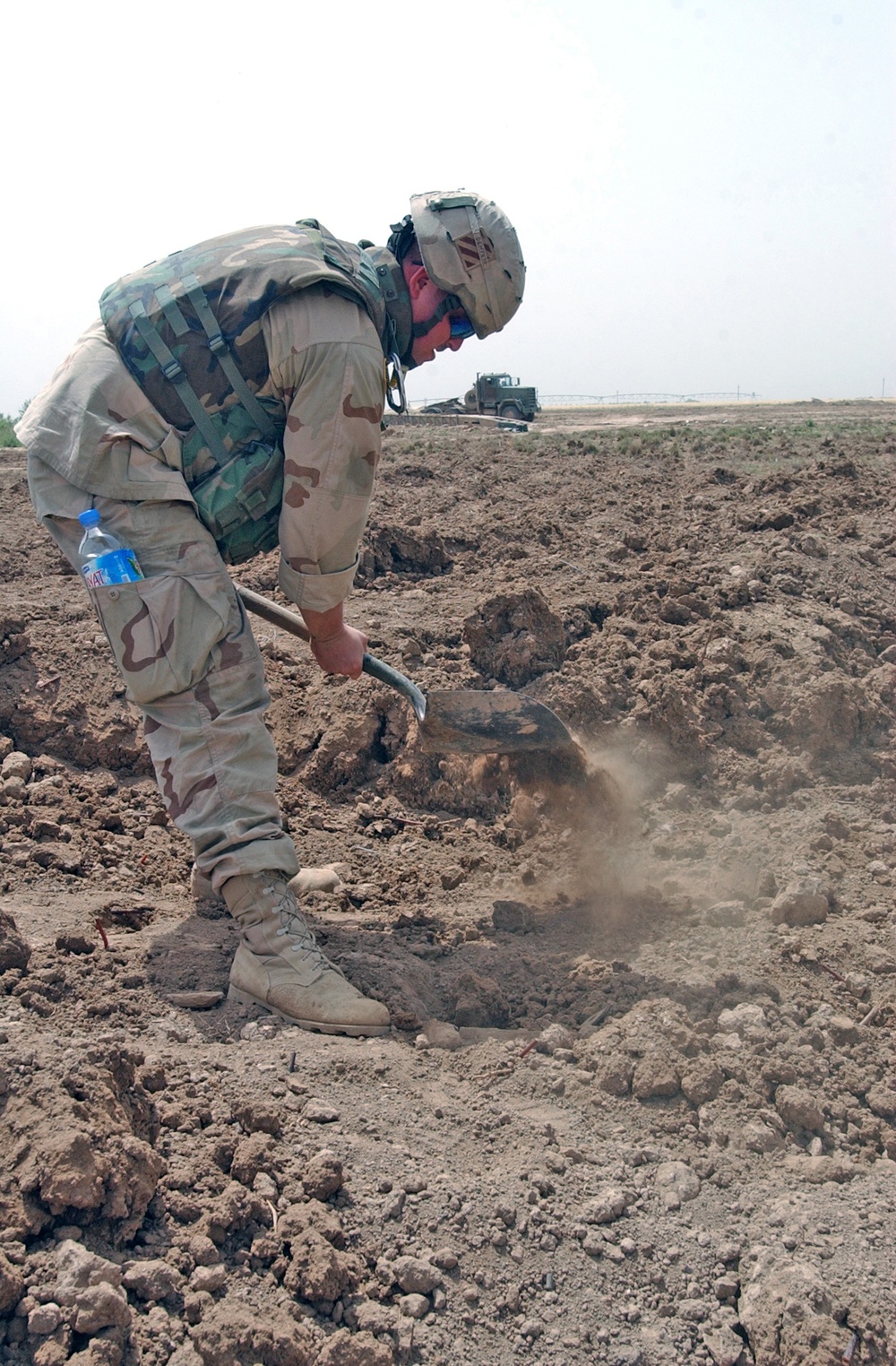 Sgt. Kevin Hanson digs in a field looking for UXOs