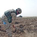 Sgt. Kevin Hanson digs in a field looking for UXOs