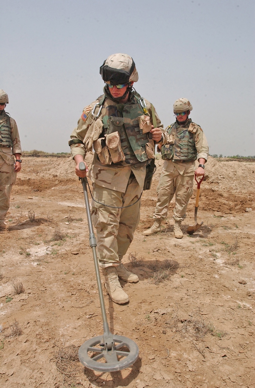 Pvt. Mark Hughes uses a mine detector to search