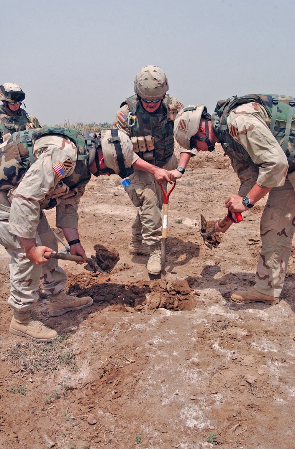 SSgt. Kradel, Spc. Carroll, and Sgt. Hanson dig for UXOs